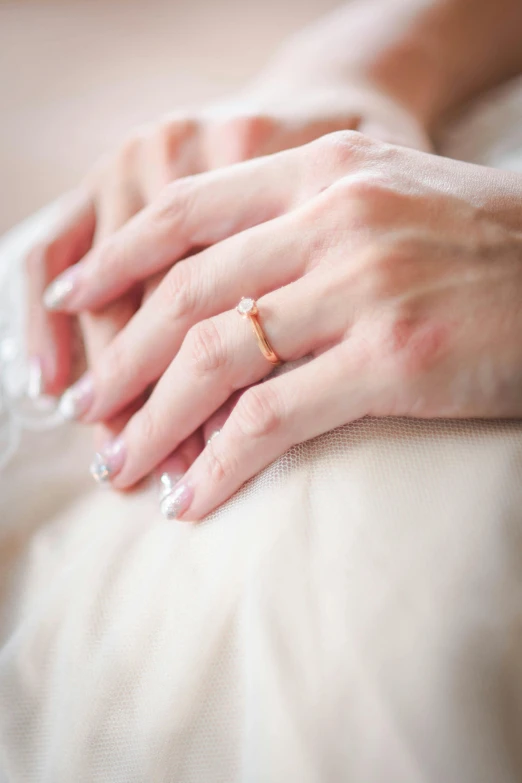 a woman with wedding rings on her fingers and the band is visible