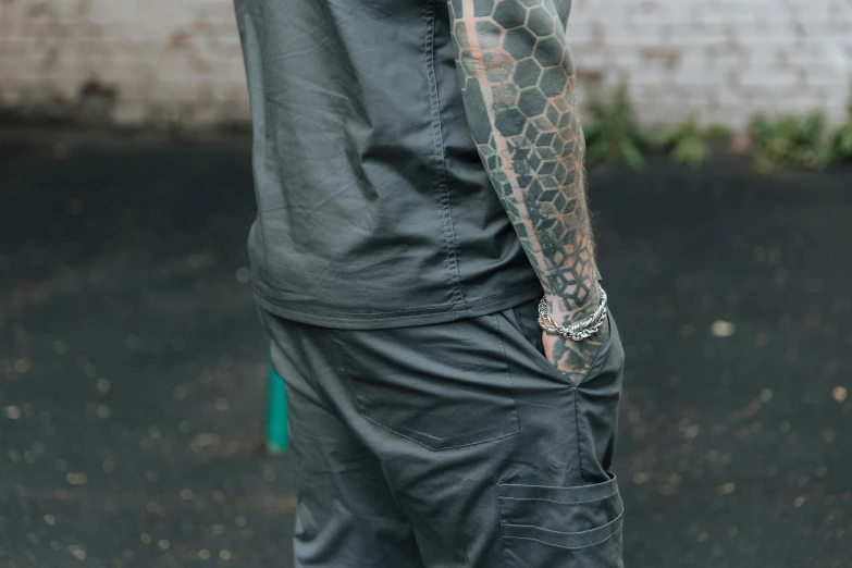 a person with tattoos on his arms holding a green umbrella