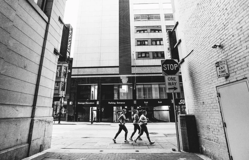 two men walking down a street next to tall buildings