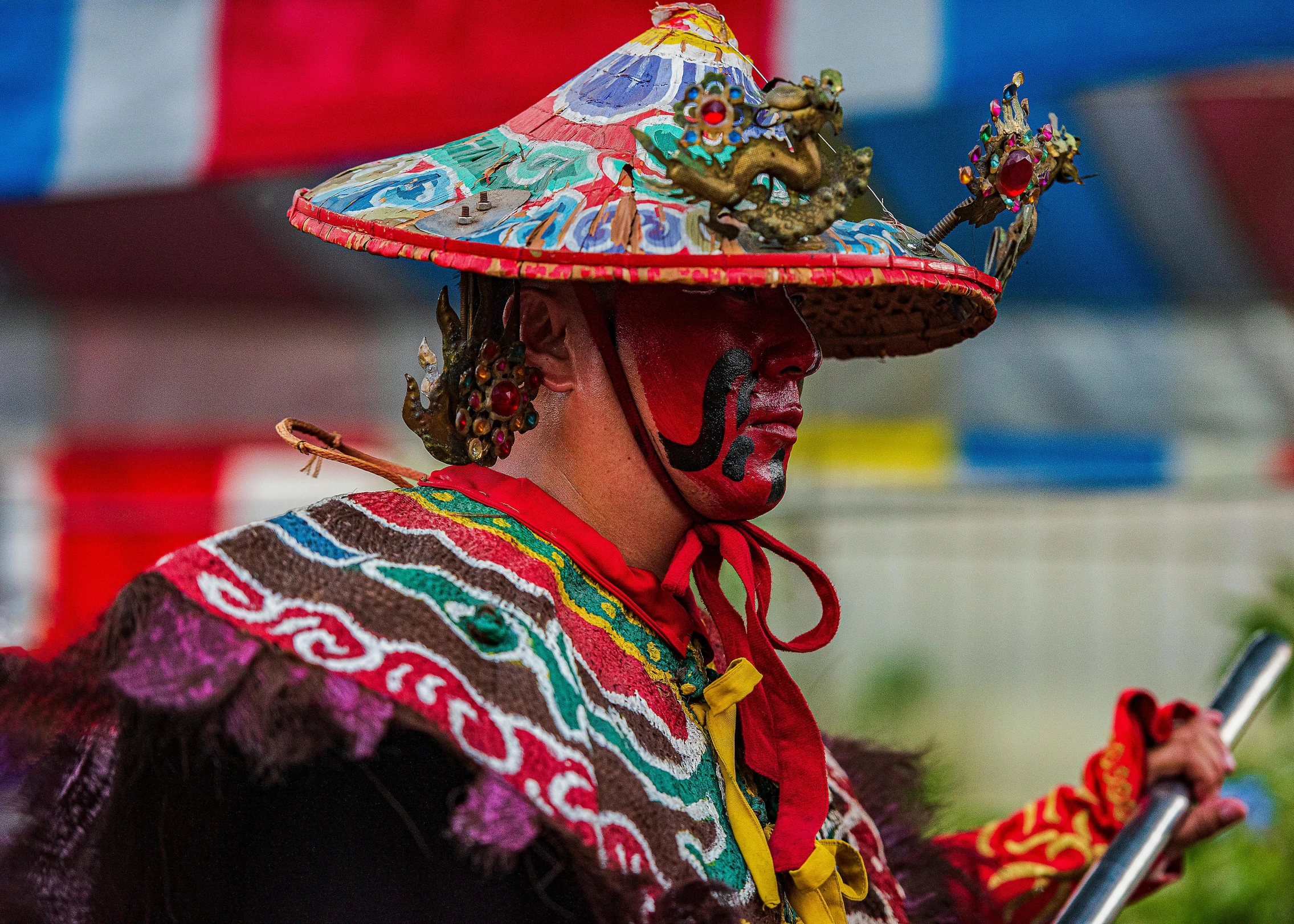 man in colorful hat walking with stick