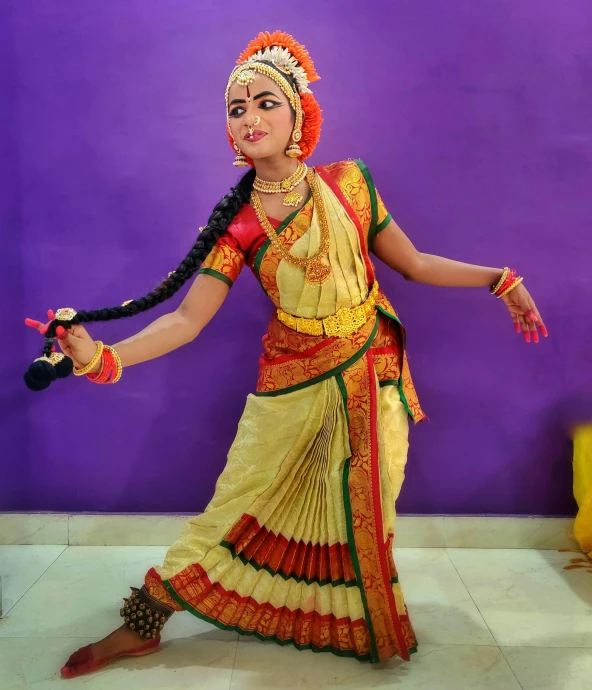 an indian woman performs in costume with a string