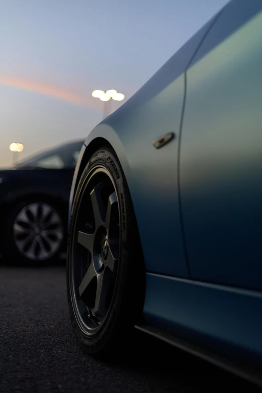 the side view of two cars with dark rims