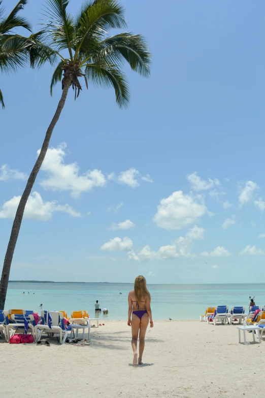 a woman in a bikini standing under a tree