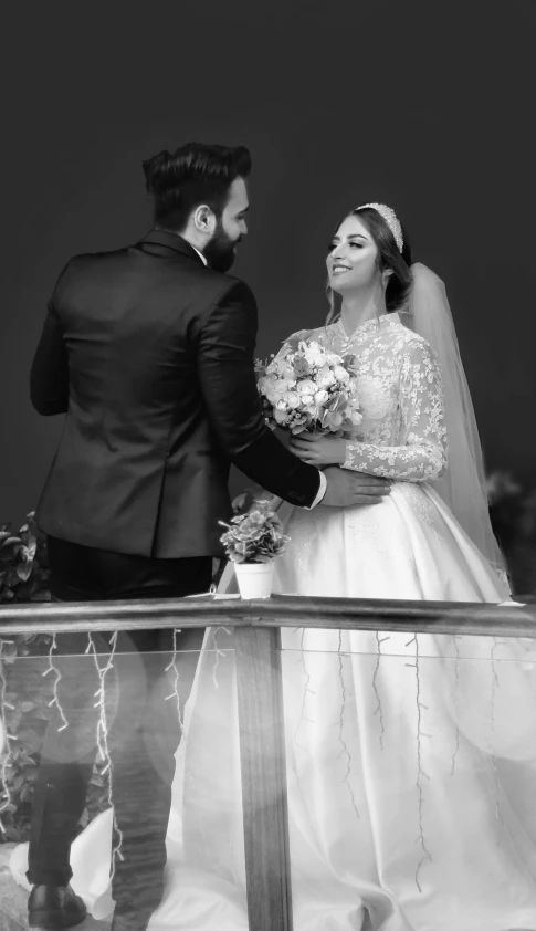 a bride and groom looking back while standing on the balcony of their wedding venue