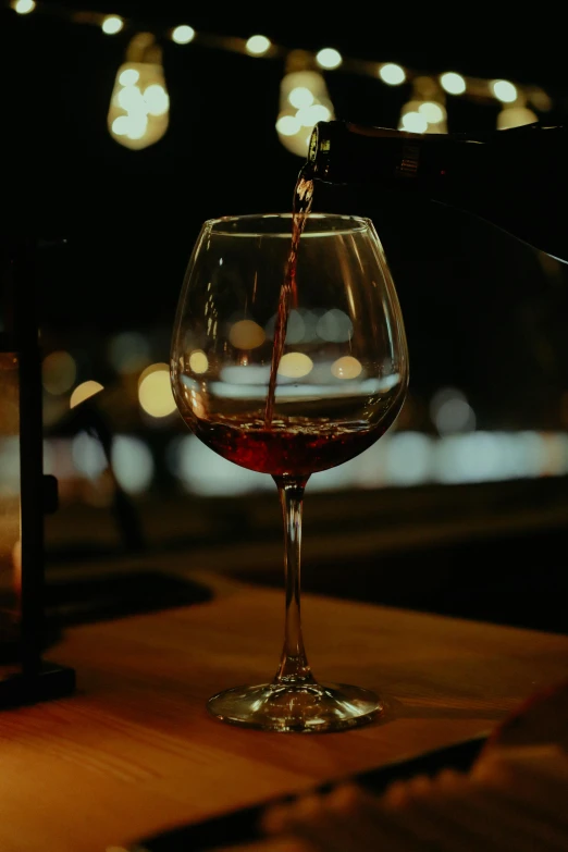 a wine glass with a wine being poured into it