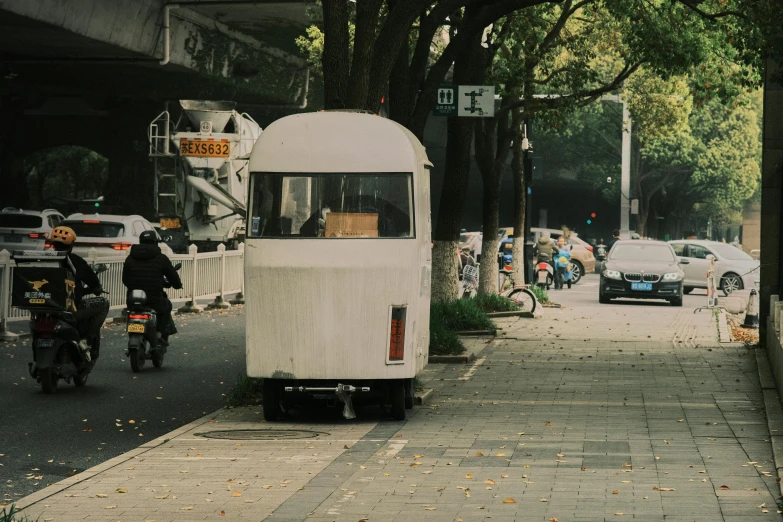 there is a tiny bus parked at the side of the road