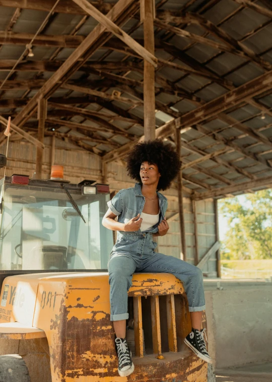 a black woman sitting on top of an old dump truck