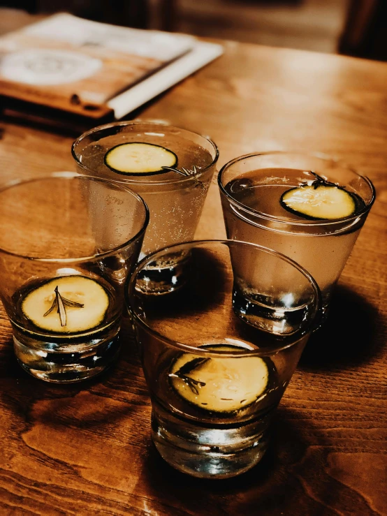 a wooden table topped with glasses filled with water