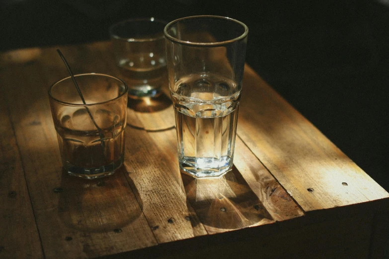 some glasses on a table, some empty and one not