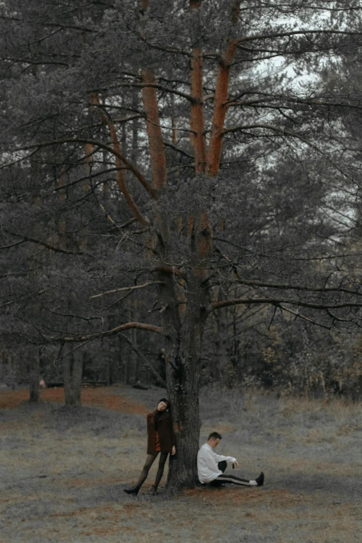 two people that are next to a tree