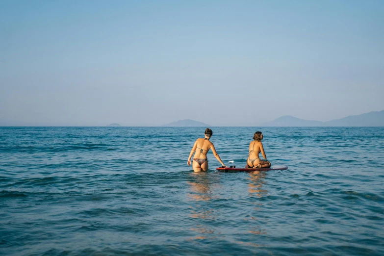 two people holding hands while standing in the ocean