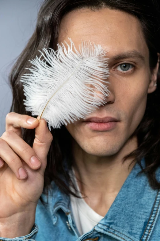 a man holds a feather in his hand