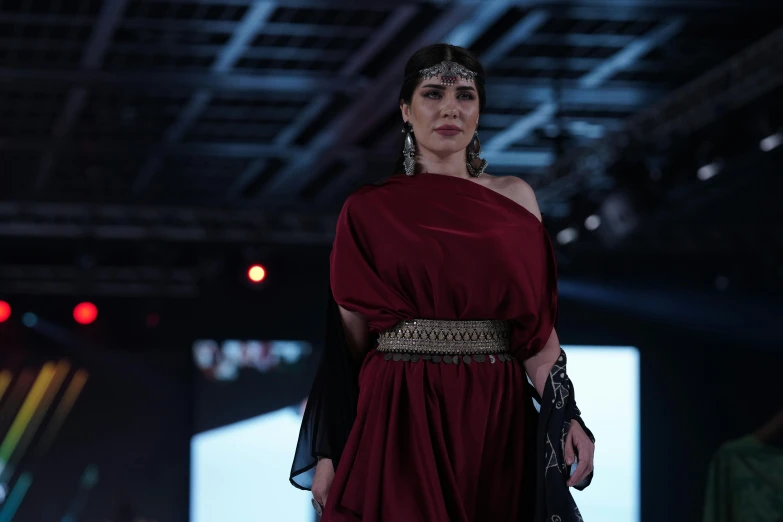 a woman in an elegant gown walks down a catwalk