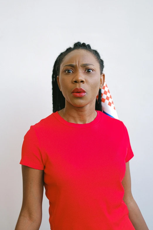 a woman standing in front of a wall with a flag on it