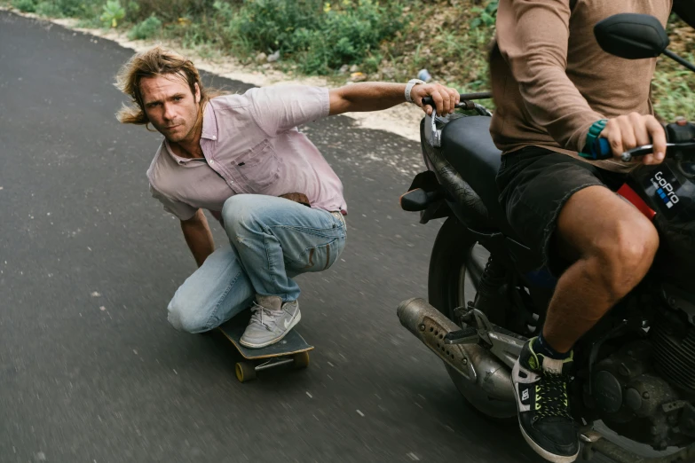 a guy riding a skateboard and another standing next to him