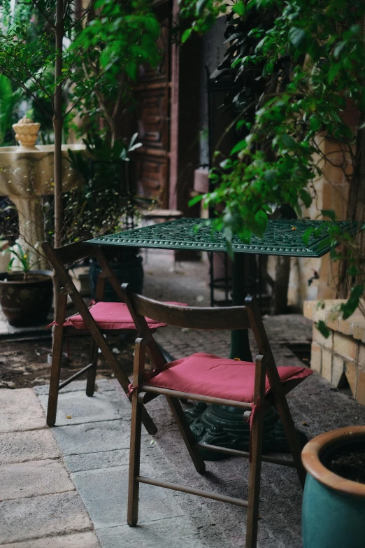 an outdoor patio with a table, chairs and plants