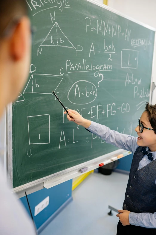 a female teacher standing by a chalk board with an erase