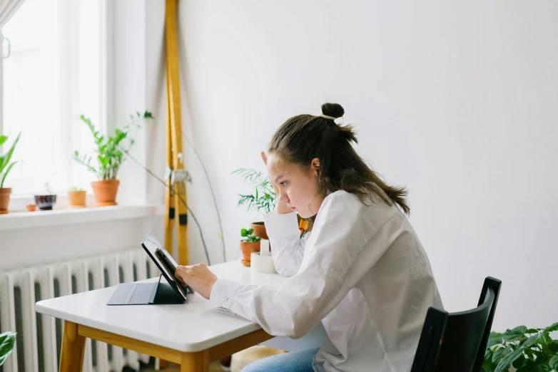 a person sitting at a table in front of a computer