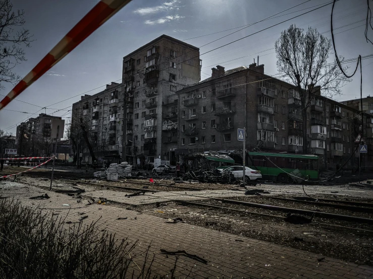 a very tall building near train tracks in a dirty city