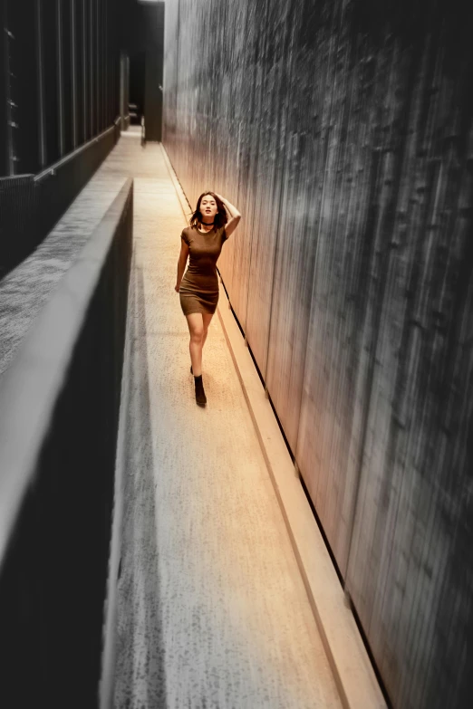 a woman walks down a long hallway in the dark