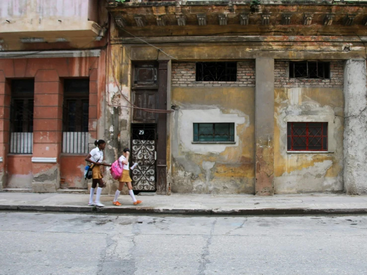 two people are walking on a street with backpacks