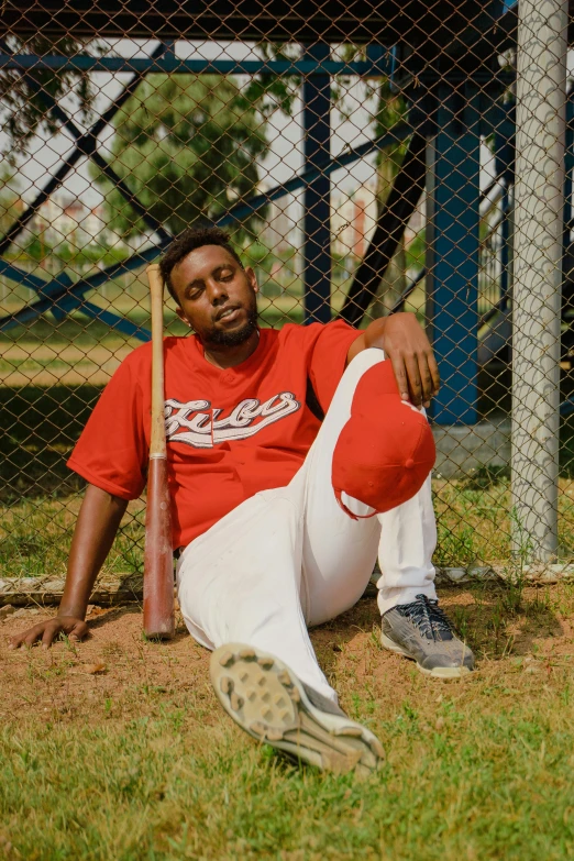 a man in a baseball uniform holding a bat on the grass