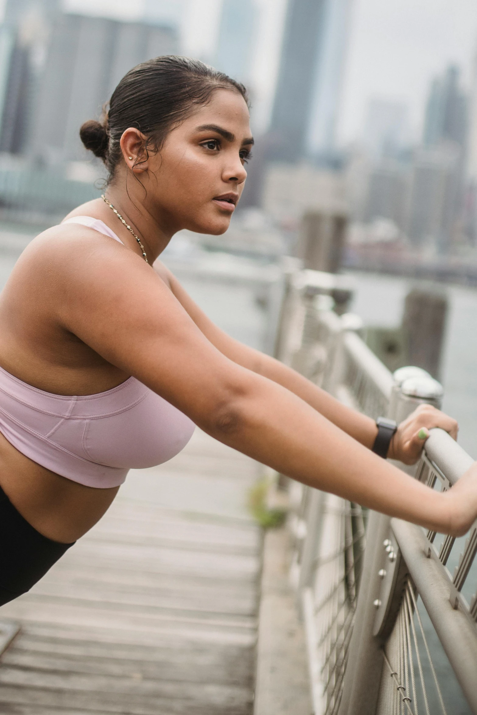 a woman wearing sports gear leaning against a railing