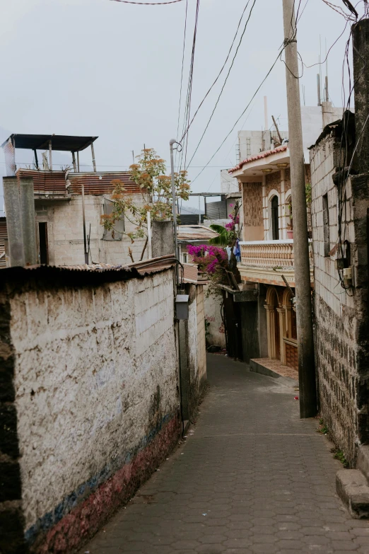 an alleyway with buildings in the background and power lines overhead