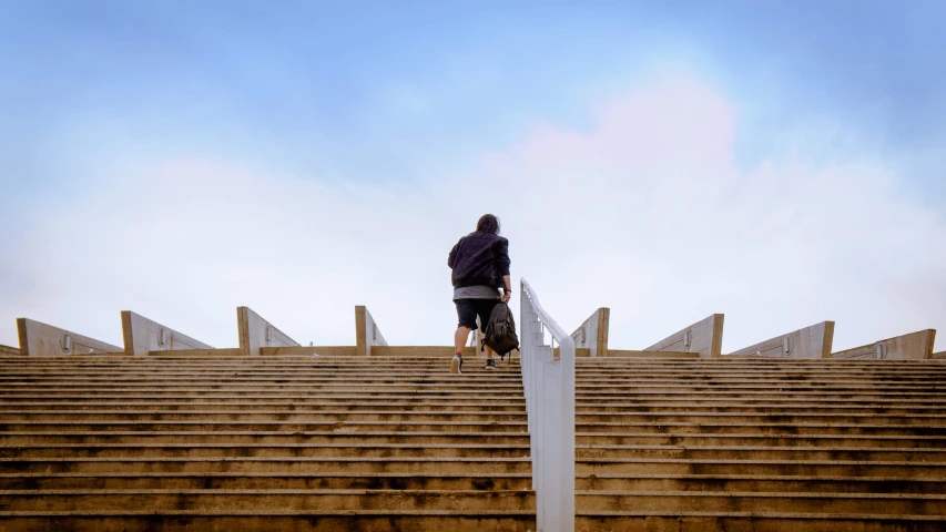 woman in wheelchair going up steps with handrail