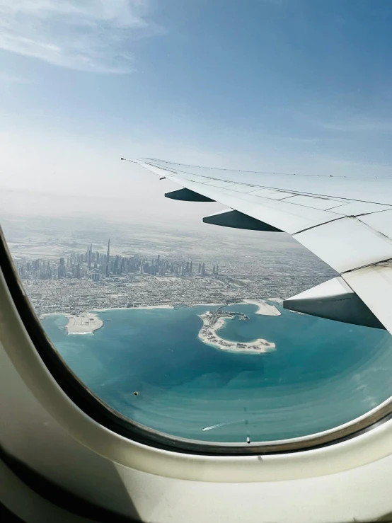 the view of some water and some buildings from an airplane window