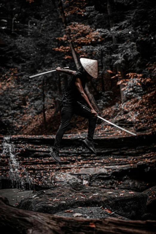 a man wearing a hat and holding a long white stick