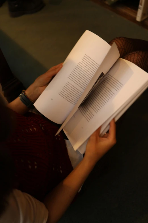 a person holding an open book in their hand