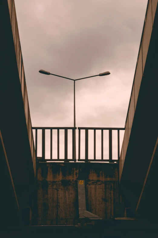 two light post standing on the side of a bridge