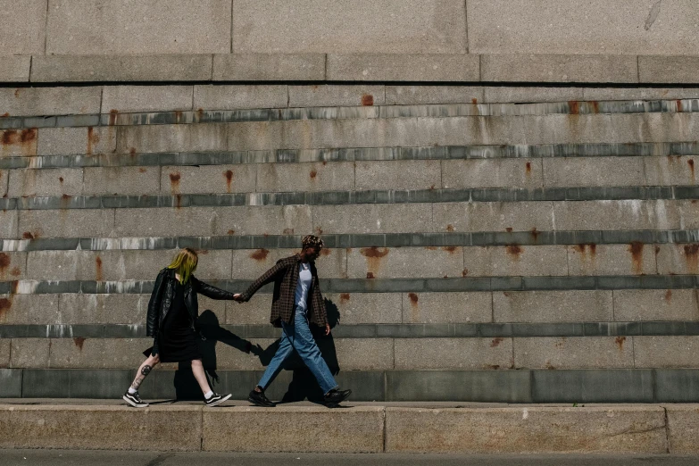 two people walking in the street holding hands