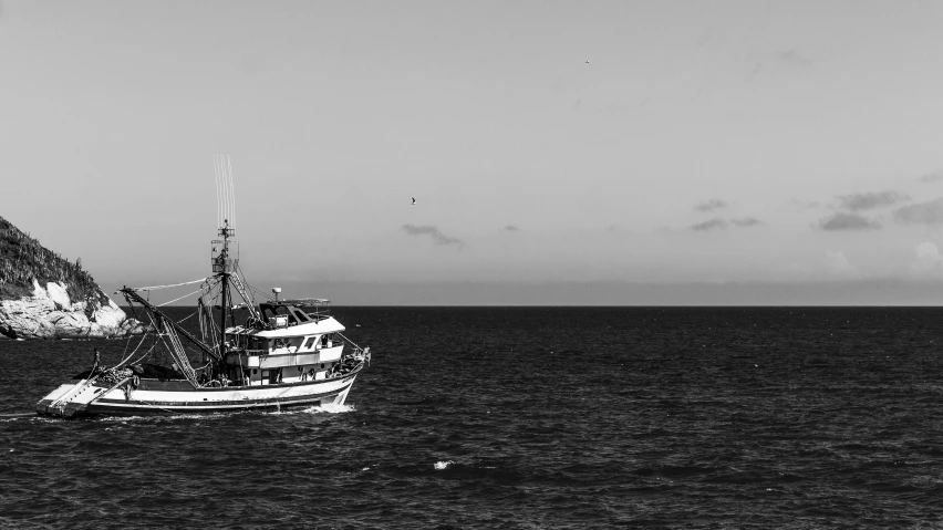 a fishing boat floats away in a large body of water