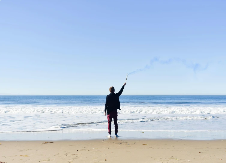 person on beach flying kite in open area of ocean