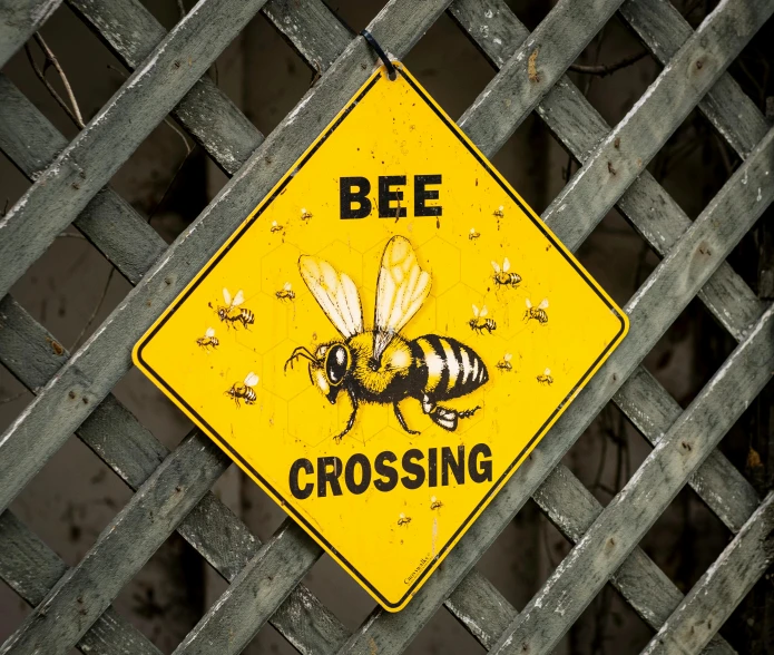 a bee crossing sign is seen on a fence