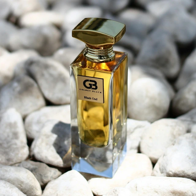 a bottle with a gold top on some rocks