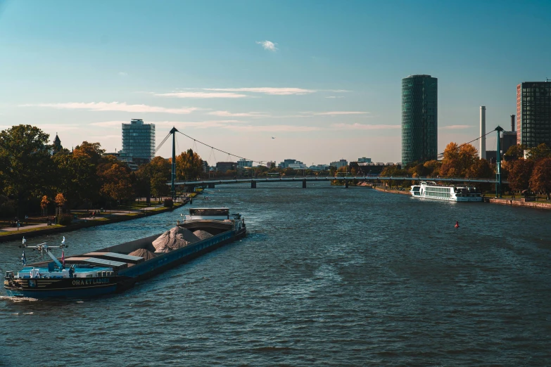 two boats traveling down a river next to tall buildings