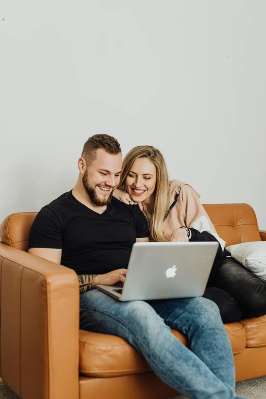 a woman sitting on top of a couch next to a man on his lap