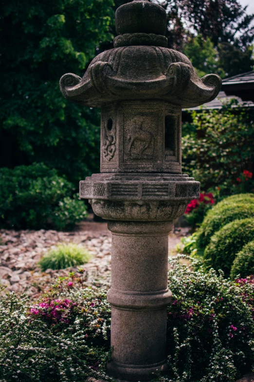 a large stone lantern in front of shrubbery