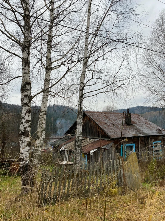 an old shack sits in the middle of a field