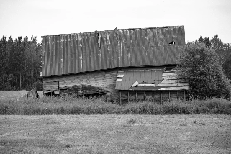 a barn sitting in a field with some trees