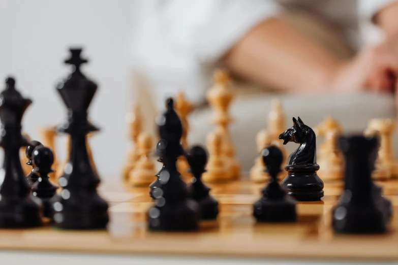 a chess set is displayed as a person plays behind