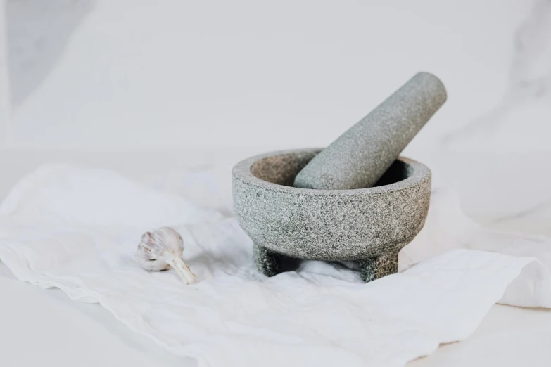 a mortar mortar bowl and a garlic in a napkin