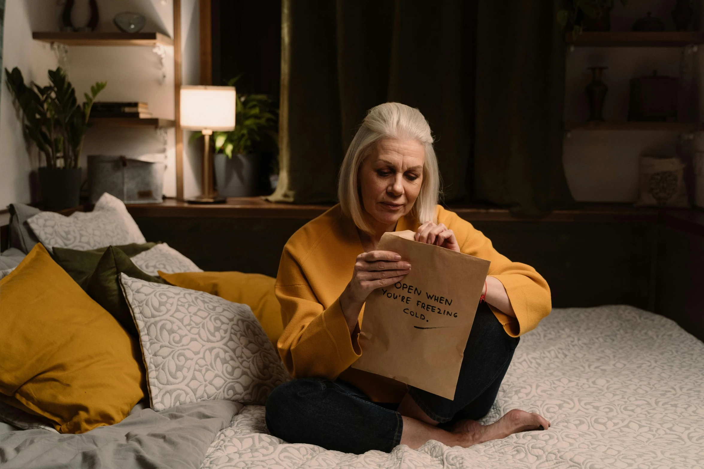 an older woman is sitting on a bed reading a book