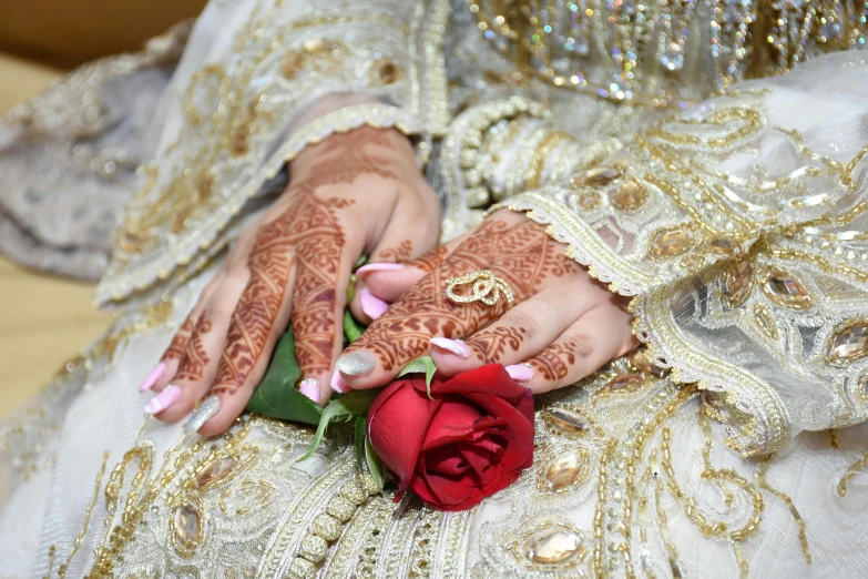 a person with henna on and a flower in her hand