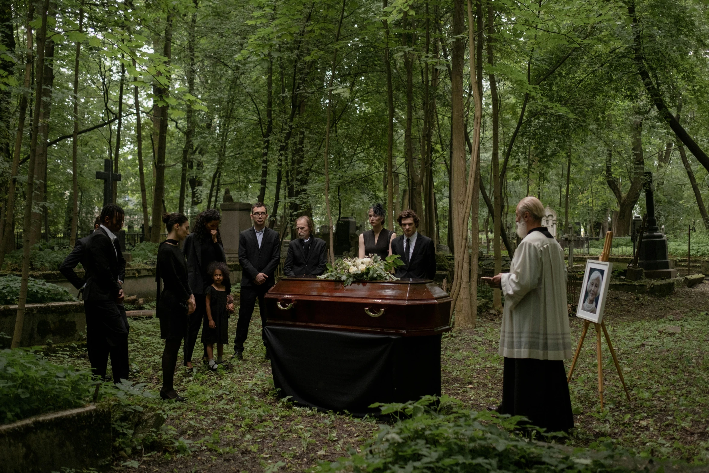 a group of men in suits stand in the woods