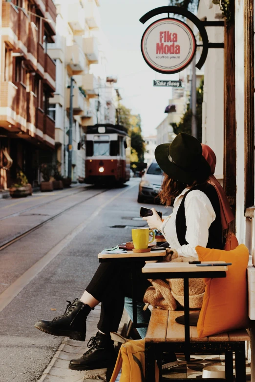 person sitting on bench with coffee and a dog