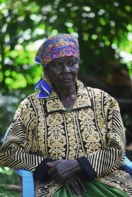 an old woman with large hands resting on a chair